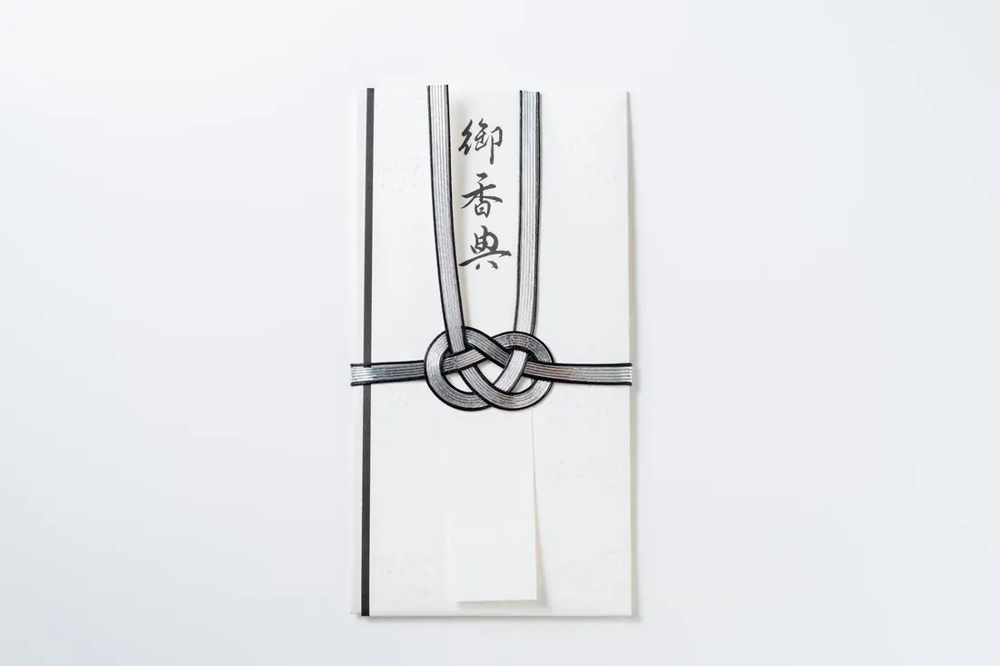 御香典と表書きされた白い不祝儀袋と黒白の水引